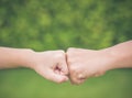 Closeup mother and son are fist bumping in green background. Royalty Free Stock Photo