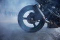 Closeup motorbike wheel over training track of driving school in smoke Royalty Free Stock Photo