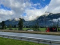 Closeup of a motorway with a track and car passing, snowy mountains, cloudy sky background Royalty Free Stock Photo