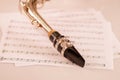 Closeup mouthpiece of saxophone lying on musical notes paper Royalty Free Stock Photo