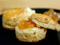 Closeup of Mouthwatering Candied Orange Zest Scones with Marmalade Jam on a Black Plate