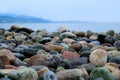 Closeup Multi-color Natural Pebble Stones on the Beach with Blurry Seascape in the Backdrop