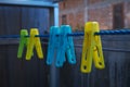 closeup multi colored clotespin hanging on a blue rope