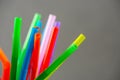 Closeup of multi colored plastic straws in a jar in front of grey background. Royalty Free Stock Photo