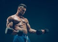 Closeup of a muscular young man lifting dumbbells Royalty Free Stock Photo