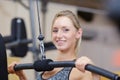 Closeup muscular young woman lifting weights in gym