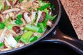 Closeup of mushrooms and leeks cooking in a pan