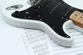 Closeup of music sheets and black-and-white electric guitar.iso Royalty Free Stock Photo