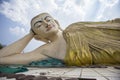 Closeup of the Mya Tha Lyaung reclining Buddha against a cloudy sky