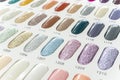 Closeup of a nail color display chart with various glittery nail choices with a numbered code. At a nail salon or spa