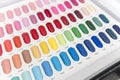 Closeup of a nail color display chart with various vibrant choices with a numbered code. At a nail salon or spa