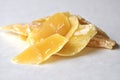 A closeup of a natural beeswax shavings for cosmetic use and candlemaking isolated on white