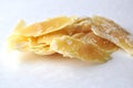 A closeup of a natural beeswax shavings for cosmetic use and candlemaking on white