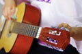 Closeup neck of beautiful acoustic guitar being tuned by woman sitting down, musician concept