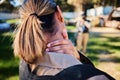 Closeup, neck pain and hand of woman with injury in paintball, sports and training on blurred background. Rear view