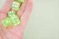 Closeup of neon green dice on a person's palm isolated on a grey background