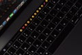 Closeup new macbook pro 2016 keyboard showing illuminated and emoji on touch bar