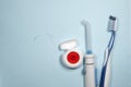 Closeup of new plastic toothbrushes, dental floss and oral irrigator on a blue background.