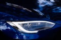 Closeup of new projector headlight on the modern blue car Royalty Free Stock Photo