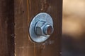 New shiny nut and two flat metal washers on the rusty bolt in the wooden board Royalty Free Stock Photo