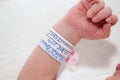 Closeup of a newborn arm and bracelet at hospital on the day of her birth