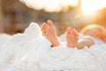 Closeup of newborn baby girl feet on white blanket at sunset outdoor Royalty Free Stock Photo