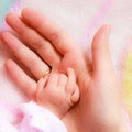 Closeup newborn baby holding his mothers finger