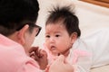 Closeup of newborn baby 3 months  eye contact with happy father with love and happiness, dad play with adorable daughter on bed, Royalty Free Stock Photo