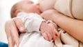 Closeup of newborn baby's hands lying on mother while sucking breast and eating milk. Concept of healthy and natural Royalty Free Stock Photo
