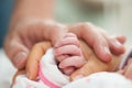 Closeup of a newborn and her parents hands at hospital on the day of her birth. Family concept. Parenthood concept Royalty Free Stock Photo