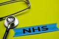 Closeup NHS with stethoscope concept inspiration on yellow background