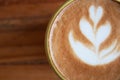 Closeup of nice latte art on a cup of coffee on a wooden surface