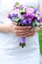 Closeup nice vioelt bouquet of flowers in fiancee hands.