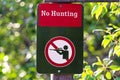 Closeup of a no hunting sign on a green background Royalty Free Stock Photo
