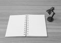 Closeup a note book with small lamp in room on wood desk textured background in black and white tone
