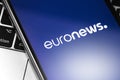 Closeup notebook and smartphone with Euronews logo on the screen