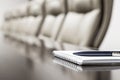 Closeup of notepad kept on table in empty conference room befor meeting Royalty Free Stock Photo