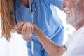 Closeup nurse doctor holding elder hand for health care support elder man happy smiling Royalty Free Stock Photo