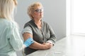 Closeup nurse doing vaccine injection to senior woman.