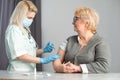 Closeup nurse doing vaccine injection to senior woman.