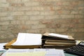 Closeup of office table and stacks of folders, documents on it against brick wall.Empty space