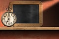 Old Alarm Clock above a Wooden Shelf with Empty Blackboard Royalty Free Stock Photo