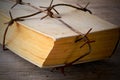 Old book wrapped with rusty barbed wire Royalty Free Stock Photo