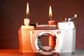 Closeup of an old broken camera with burning candles on it on a blurry background Royalty Free Stock Photo