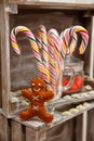 Closeup of an old fashioned candy cane and a gingerbread man on a wooden box