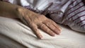 Closeup of old female hand in bed Royalty Free Stock Photo