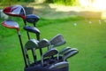 Closeup old golf bags on green. Set of golf clubs over green field background Royalty Free Stock Photo