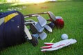 Closeup old golf bags on green. Set of golf clubs over green field background Royalty Free Stock Photo