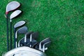 Closeup old golf bags on green. Set of golf clubs over green field background Royalty Free Stock Photo