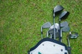 Closeup old golf bags on green. Set of golf clubs over green field background